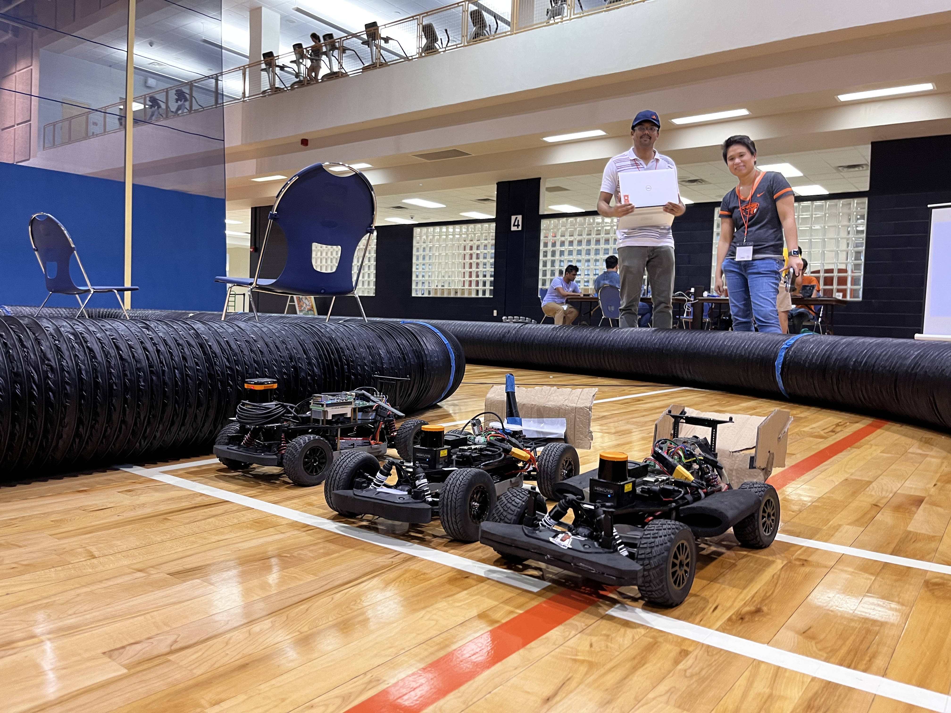 three f1tenth vehicles lined up side-by-side on the track